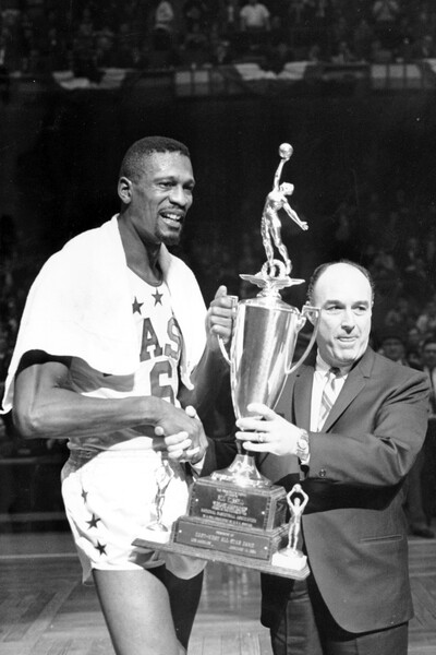 Билл Расселл получает награду «Игрок года» от комиссара Национальной баскетбольной ассоциации (НБА) Уолтера Кеннеди во время перерыва в&nbsp;матче в&nbsp;Бостон-Гарден, 1964&nbsp;год