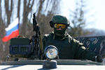 Военнослужащий в форме без опознавательных знаков у военной базы в селе Перевальное в Крыму 