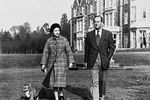 Елизавета II с супругом Филиппом гуляют с собакой на территории Сандрингемского дворца в Норфолке, 1982 год 