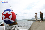 Лидер КНДР Ким Чен Ын (справа) на церемонии спуска на воду новой тактической атомной подводной лодки в Северной Корее, 8 сентября 2023 года