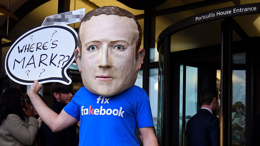 Активист в маске с изображением основателя Facebook (компания-владелец Meta признана экстремистской организацией) Марка Цукерберга во время акции в Лондоне, ноябрь 2018 года