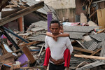 Мужчина с ребенком на фоне разрушенных домов в Чианджуре, Инднезия, 22 ноября 2022 года