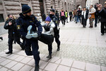 Полицейские задерживают Грету Тунберг во время демонстрации возле здания шведского парламента вместе с группой климатических активистов в Стокгольме, Швеция, 13 марта 2024 года