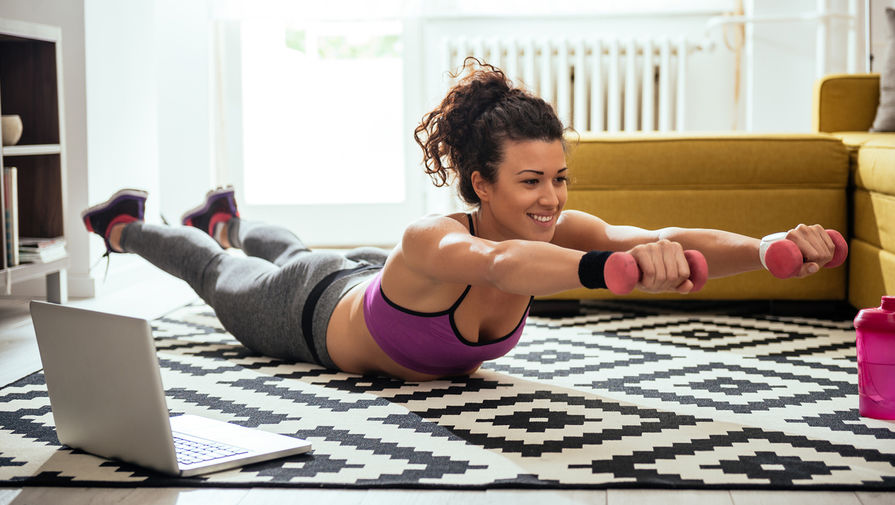 Young woman exercising at home in a living room.
