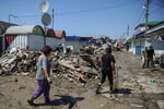 Рабочие проходят мимо разрушенных торговых павильонов на рынке Крымска, июль 2012 года