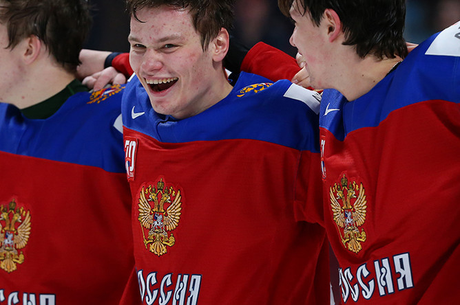 Игрок сборной России Михаил Сергачёв (в центре) на церемонии награждения после окончания матча за 3-е место молодёжного чемпионата мира по хоккею между сборными командами России и Швеции