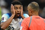 Игрок сборной Англии Джуд Беллингем спорит с рефери во время матча между сборными Англии и Франции на Чемпионате мира-2022 в Катаре

