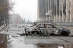Сожженный во время беспорядков автомобиль возле здания городской администрации Алма-Аты, 7 января 2022 года