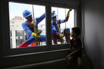 Мужчины в костюмах Супермена и Капитана Америки во время мойки окон детской больницы в Сан-Паулу, Бразилия, 2013 год