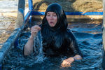 Священнослужительница во время крещенских купаний в купели на реке Тура в Тюмени, 19 января 2022 года 