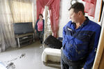 Семейная пара осматривает свой дом в Крымске после наводнения, июль 2012 года