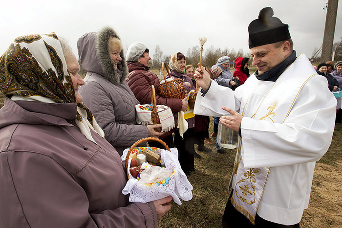 Католический священник благословляет корзины еды накануне Пасхи в&nbsp;селе Крутиловичи к&nbsp;юго-западу от Минска
