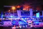 Машины скорой помощи и бронеавтомобиль Росгвардии у концертного зала «Крокус Сити Холл», где произошла стрельба, 22 марта 2024 года