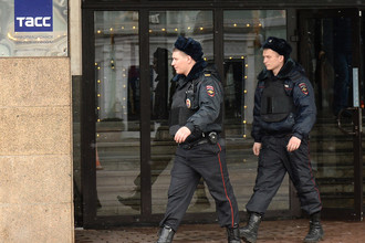 Сотрудники полиции у входа в здание информационного агентства России ТАСС на Тверском бульваре, где прошли обыски.