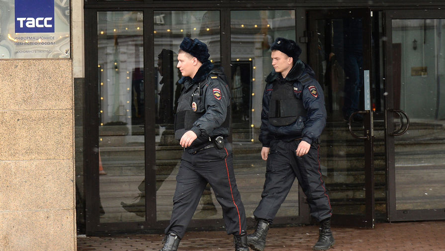 Сотрудники полиции у входа в здание информационного агентства России ТАСС на Тверском бульваре, где прошли обыски.