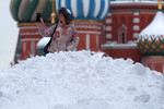 Девушка фотографируется возле сугроба на Красной площади в Москве, 19 января 2024 года
