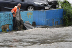 Вода уходит в ливневую канализацию на одной из улиц Владивостока, затопленных в результате сильного ливня, 25 августа 2023 года
