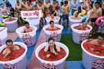 Участники соревнования принимают ванну в бочках с перцем Чили, во время конкурса Spicy Barrel Challenge в аквапарке в Чунцине, Китай, 7 июля 2018 года
