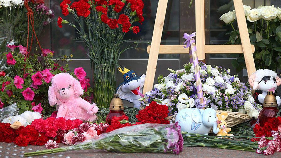 Цветы и игрушки у здания департамента труда и социальной защиты в память о погибших детях на озере в Карелии