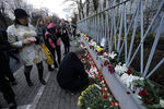 Жители Риги несут цветы в память о жертвах теракта к посольству Франции