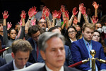 Пропалестинские активисты поднимают «окровавленные» руки во время слушаний с участием госсекретаря Энтони Блинкена и главы Пентагона Ллойда Остина в конгрессе США, 31 октября 2023 года