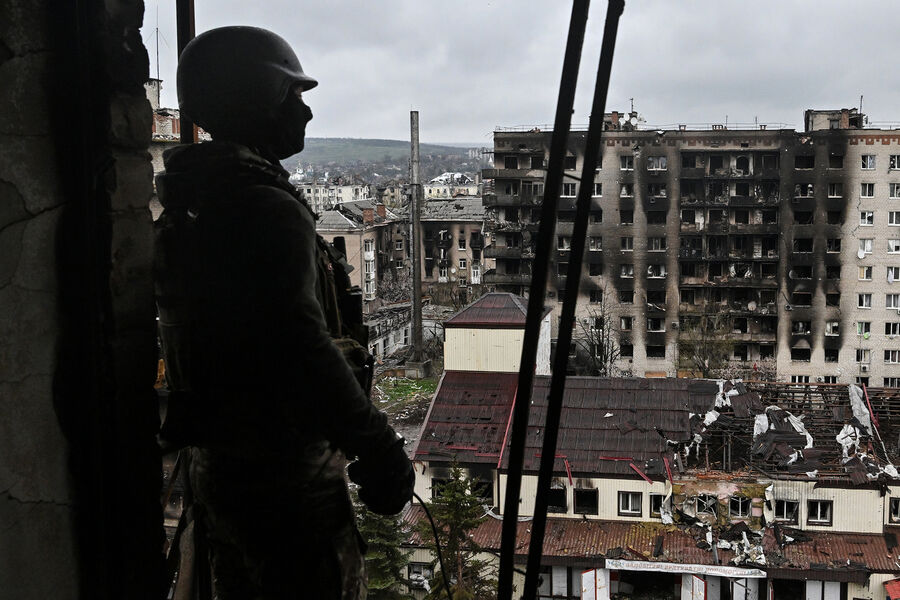 Боец ЧВК «Вагнер» осматривает разрушенный район Артёмовска