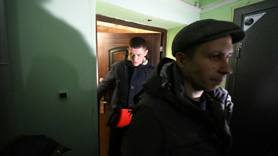 Трое следователей выходят из квартиры, где произошло преступление 
