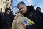 Бывший президент Украины Петр Порошенко обнимает женщину, подарившую ему украинский флаг, во время церемонии памяти о Революции на Майдане в Киеве, Украина, 20 февраля 2022 года 