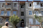 Поврежденный дом и местные жители в Степанакерте, 13 октября 2020 года