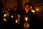 Верующие держат свечи во время пасхальной мессы в Вильнюсе, Литва