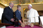 Николай Лукашенко с отцом во время визита в Ватикан преподносят папе Римскому Франциску копию креста Евфросинии Полоцкой, модель кареты и голографическую икону, 2016 год