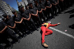 Журналист в образе «Джокера» у ног сотрудников полиции во время однодневной общенациональной забастовки у здания Национального конгресса в Буэнос-Айресе, Аргентина, 24 января 2024 года