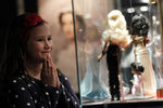 Девочка разглядывает кукол на выставке Барби в Загребе, май 2012 года