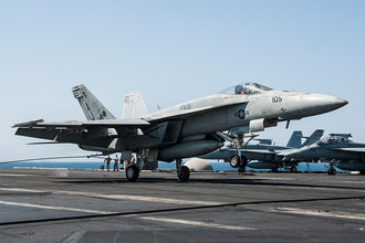 Американский палубный истребитель-бомбардировщик F/A-18E Super Hornet во время посадки на авианосец «Джордж Буш», после атаки по позициям террористической группировки «Исламское государство»