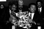 Чемпион в супертяжелом весе на пресс-конференции в Нью-Йорке держит комикс «Супермен против Мухаммеда Али», 1978 год