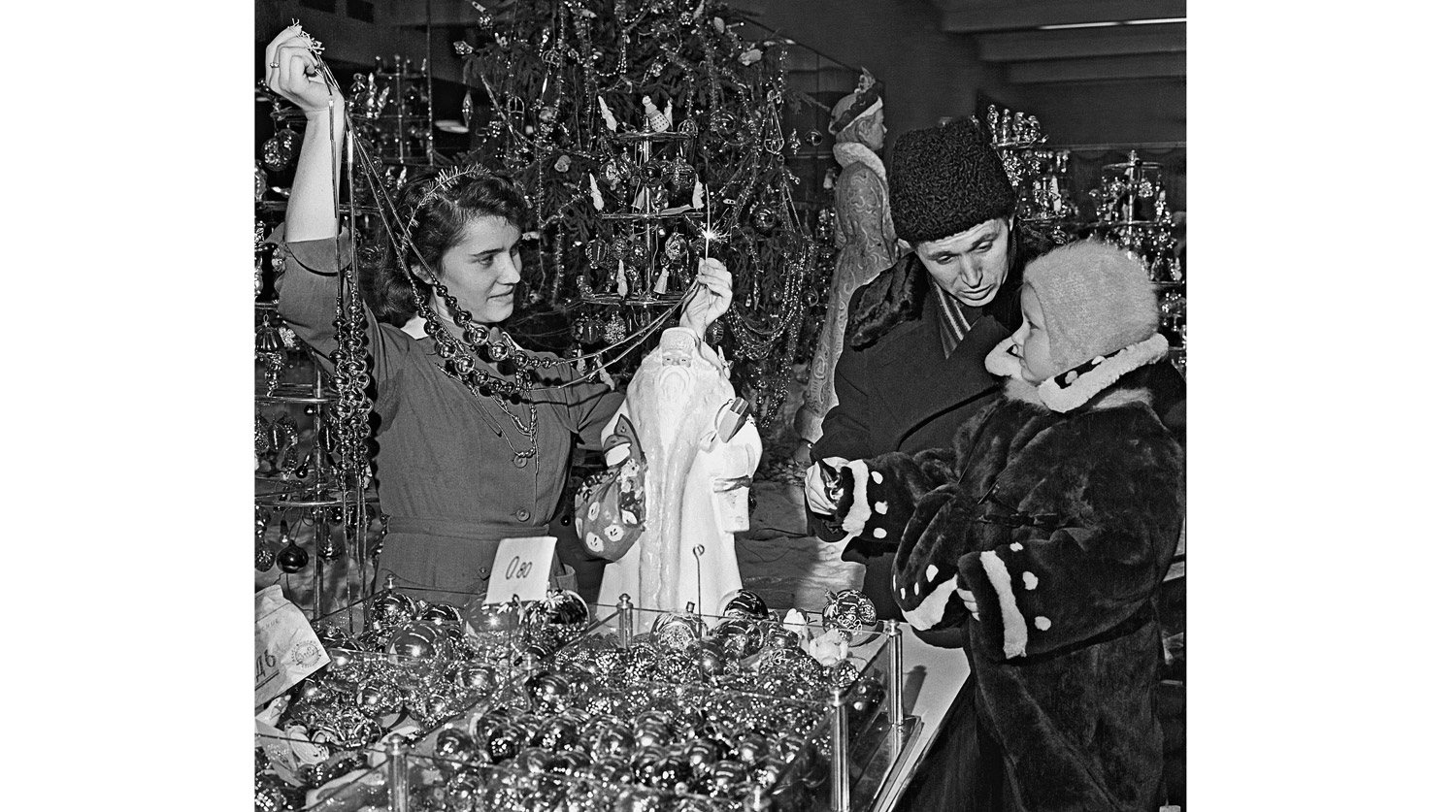 1958 год. Папа с маленькой дочкой выбирают елочные украшения