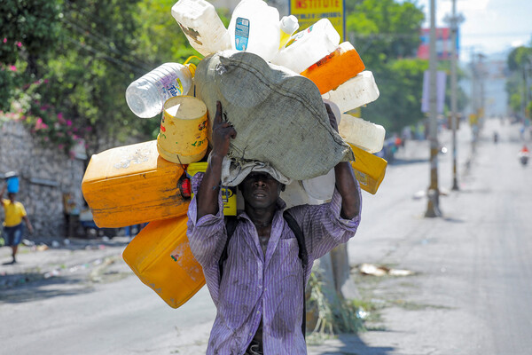 Житель Порт-о-Пренс с&nbsp;тарой для&nbsp;питьевой воды, Гаити, 17&nbsp;сентября 2022&nbsp;года