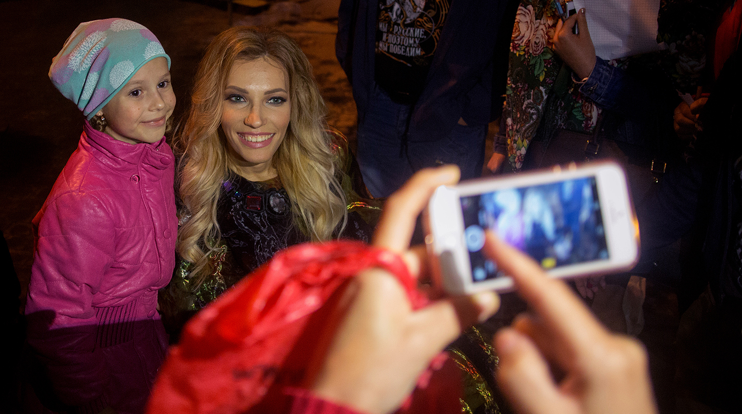 Певица Юлия Самойлова фотографируется с поклонниками после окончания концерта, посвященного празднованию Дня Победы, на площади Нахимова в Севастополе