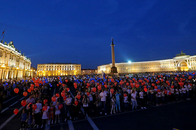 Горожане во время флешмоба на Дворцовой площади, приуроченного к празднованию Дня Государственного флага Российской Федерации