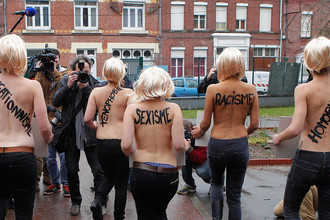 Акция активисток движения FEMEN против Марин Ле Пен. На спинах женщин надписи: «расизм», «сексизм» и «ксенофобия»