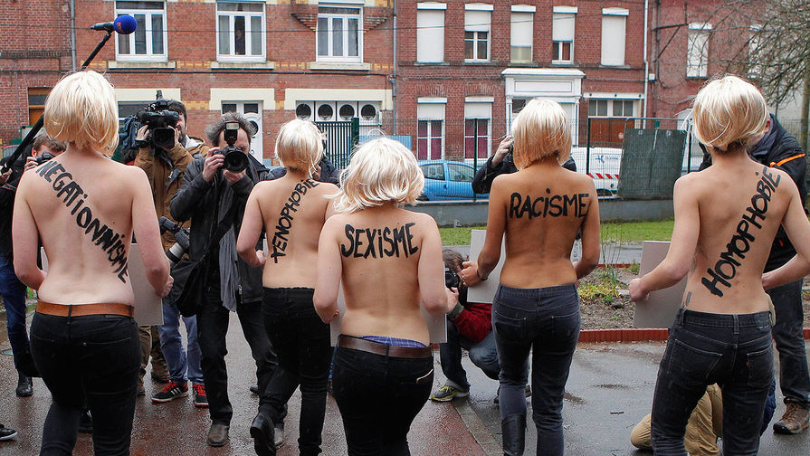 Акция активисток движения FEMEN против Марин Ле Пен. На спинах женщин надписи: «расизм», «сексизм» и «ксенофобия»