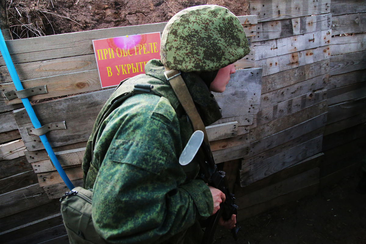 Боец Народной милиции ДНР передвигается по окопу между позициями на западной окраине Донецка на линии соприкосновения, 2021 год