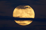 Самолет на фоне Луны в небе над Сан-Диего