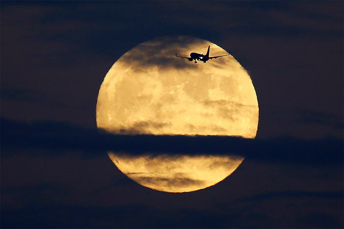 Самолет на&nbsp;фоне Луны в&nbsp;небе над&nbsp;Сан-Диего