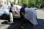Сотрудники ОБСЕ укрывают автомобиль после инцидента