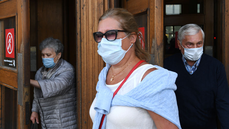 Пассажиры в медицинских масках выходят из вестибюля станции метро «Парк культуры» в Москве