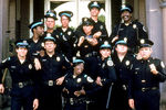 Мэрион Рэмси (внизу в центре) и актеры из фильма «Полицейская академия»