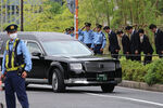 Полицейские воздают почести умершему бывшему премьер-министру Японии, пока катафалк с его телом отправляется из храма на кремацию, Токио, 12 июля 2022 года