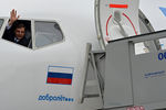 Командир экипажа самолета авиакомпании «Добролет» машет рукой в окно кабины в аэропорту Шереметьево