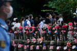 Люди стоят в очереди вдоль буддийских божеств-хранителей детей и путешественников перед молитвой, чтобы отдать дань уважения бывшему премьер-министру Японии Синдзо Абэ в храме Дзодзёдзи перед его похоронами, Токио, 12 июля 2022 года